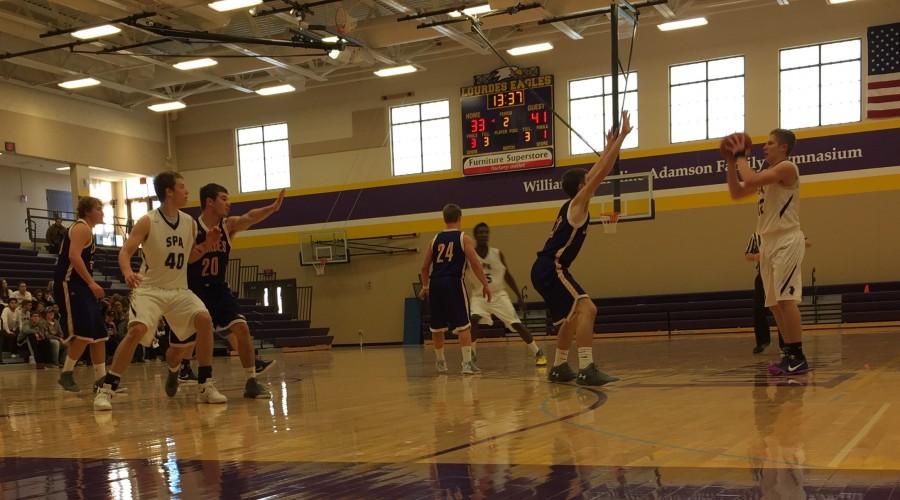 Senior Charlie Hooley fakes a pass to the post in the Spartans 58-55 Saturday win against the Lourdes Eagles.