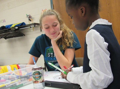 Sophomore Greta Sirek sits with a child in the Conway Recreation Center.