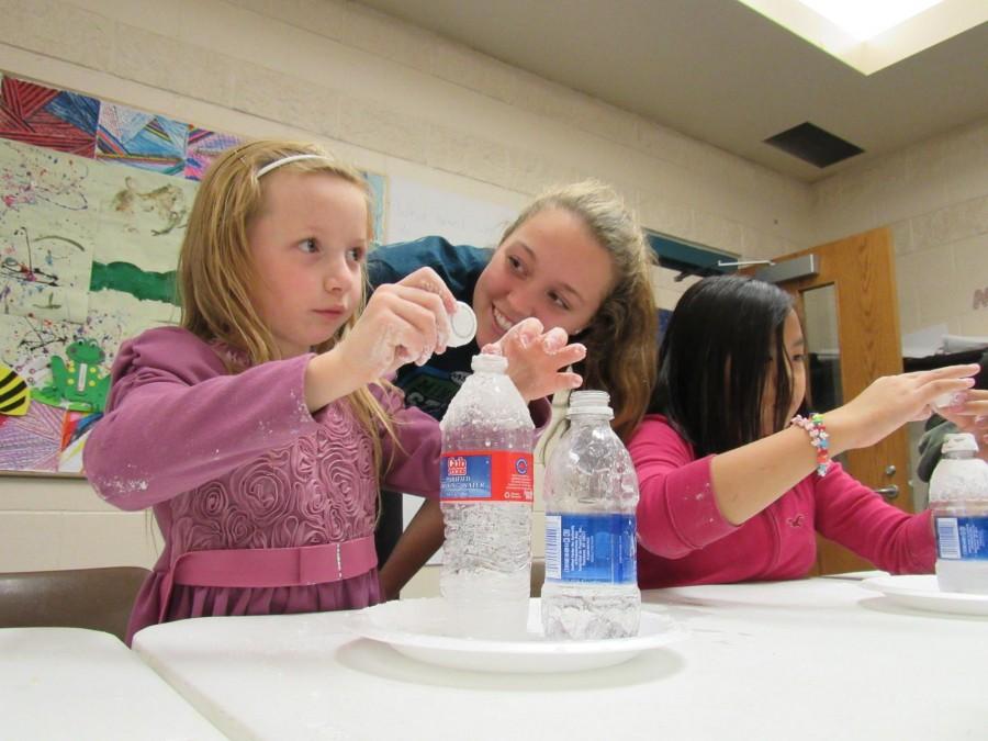 Sophomore Greta Sirek, a volunteer at Conway Recreation Center, helped children conduct volcano experiments with baking soda and vinegar. “I love seeing the kids smile and it’s fun when I come back after a while and the kids run up to me and give me a hug,” Sirek said. 