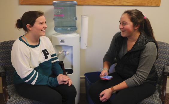 JUNIOR SAMANTHA BLUHM AND FRESHMAN LUCIE HOESCHEN laugh with each other during a dyad. This was the first of two scheduled times for dyads, the other for sophomores and seniors.  “I really enjoyed the dyads and I carry the advice that the juniors gave me on Mix It Up Day,” Hoeschen said. 