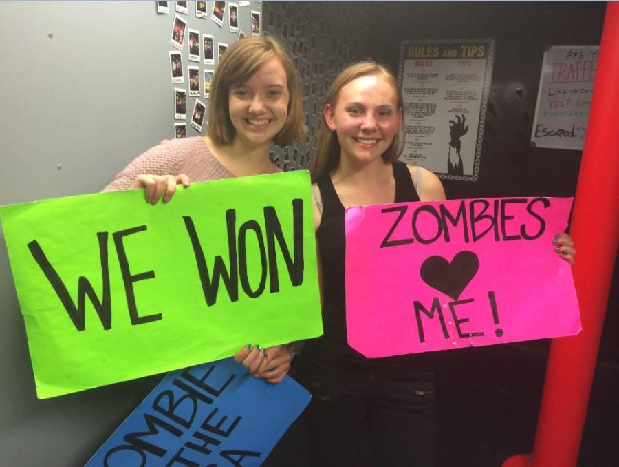 Seniors Meghan Joyce and Calla Saunders hold up signs although they didn’t escape in time.