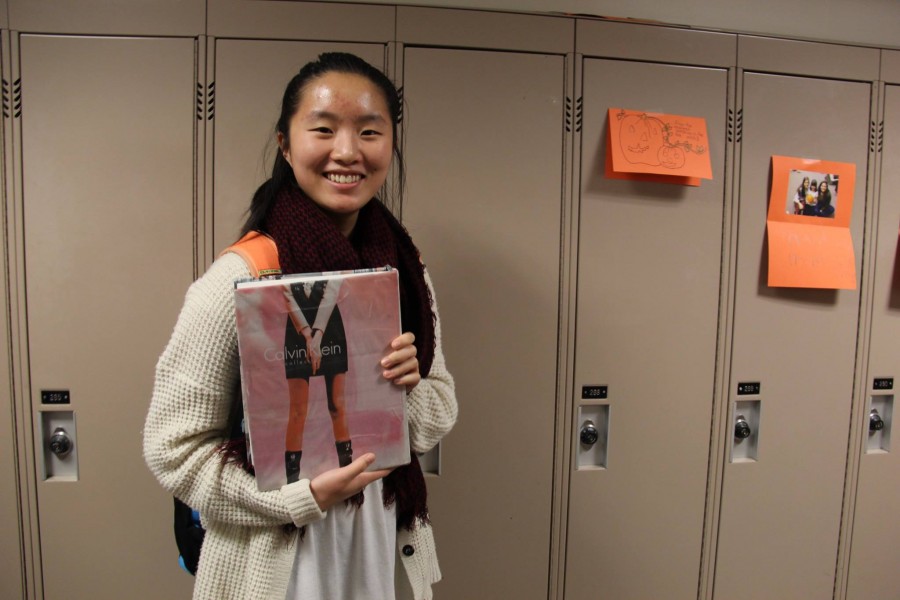 SENIOR CHRISTINE LAM poses with her textbook. “It’s really interesting, because I can sometimes read the articles… the section I pulled out was about fashion, which is interesting to me.” Lam said.