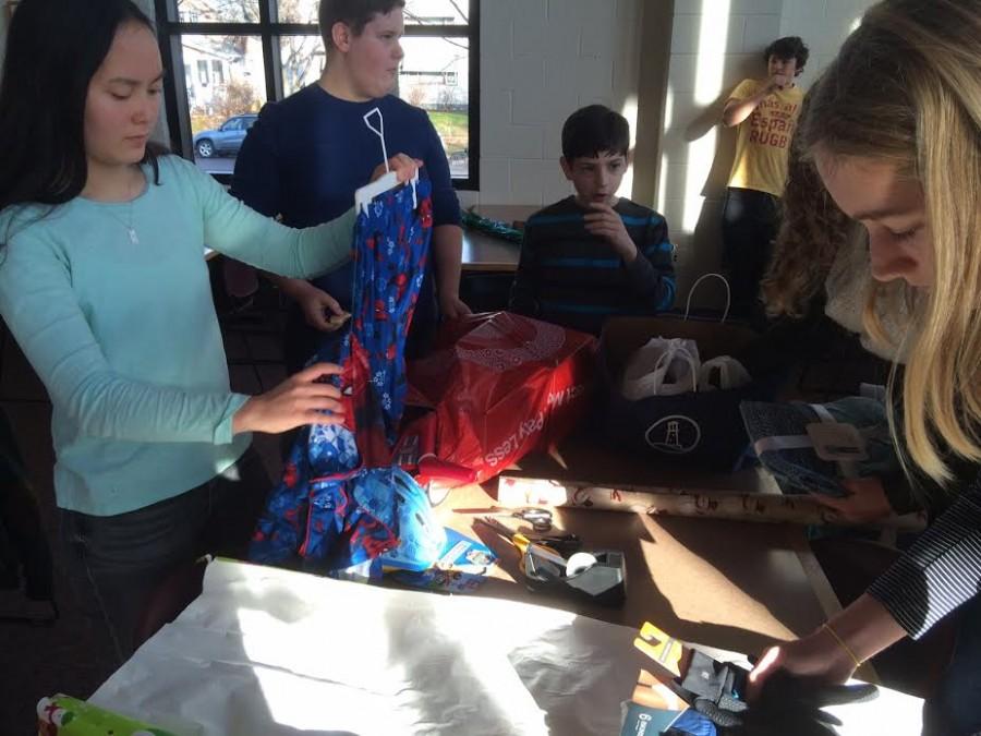 Freshmen Gemma Yoo, Riley Tietel, Isaac Fink, and Maggie Hlavka wrap gifts for 4-year-old Jayce. Jayce wanted pajamas and socks, and really likes Spider-Man. "It was sad to see that a kid needed socks for Christmas,” Freshman Riley Tietel said, “It make you realize how privileged you are.”
