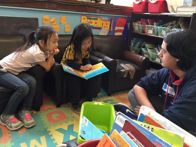 Freshman Daven Rock listens intently to first grade students from the Community School of Excellence.