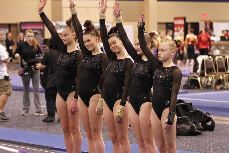 Junior Raegan Small (second from left) stands with her teammates for the floor event.
