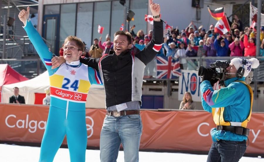 Michael “Eddie” Edwards (Taron Egerton) and Bronson Piery (Hugh Jackman) pose after Eddie’s 70m jump at the 1988 Winter Olympics.