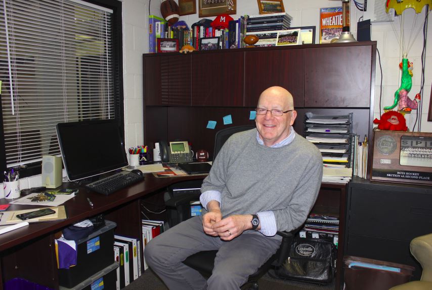 Assistant Director of Athletics Mike Brown sits at his desk, surrounded by memorabilia. "There's so much good that here... Leaving that behind is going to be sad, and not seeing the kids every day -- I'll miss that immensely," he said. 