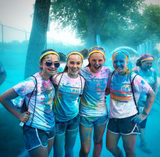 FRESHMAN JENNIE VERHEY poses with friends at the end of the race as they get blasted with color dust.  “I don’t usually like to run by myself,  so running with friends and at such a cool event was fun,”  Verhey said.