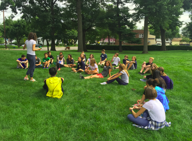 A group of freshmen listen to instructions for a yard game at retreat. We got a super helpful tour of the school, freshman Kathleen Bishop said.