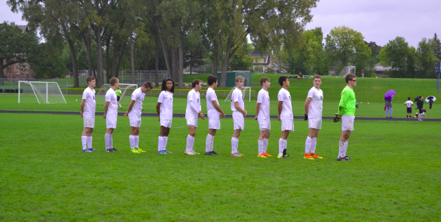 The Boys Varsity Soccer starters line up for the national anthem before the game.