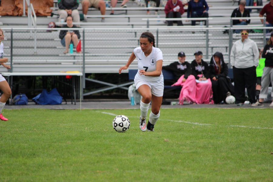 KICK IT! Senior Maggie Gallagher sprints to kick the ball up the field. "We are very loud and we get along really well, but we can also focus when we need to," senior captain Maria Perkkio said
