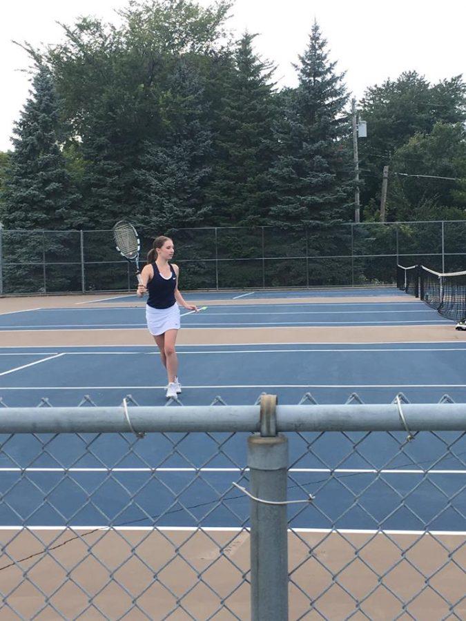 RUN AND HIT. Junior Isabel Brandtjen runs across the tennis court.