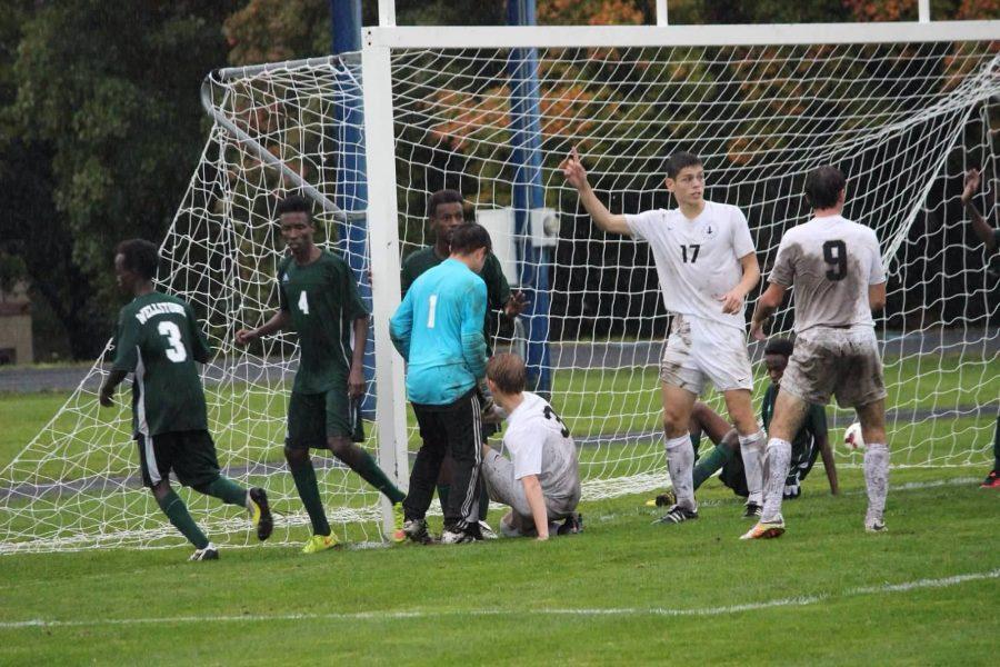 DRIBBLE AND PASS. Colin O’Hern (#9) Eric Lagos (#17) and Robin Bartlett (# 3) in a muddy scramble in front of the net during the Homecoming game on Sept. 23 against Wellstone International. The game was called for lightning, but the Spartans won 3-0.