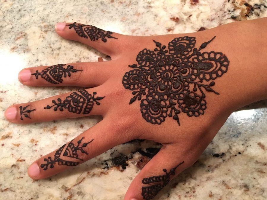 Senior Sarah Murad decorates her hand with henna on Eid al-Adha. 