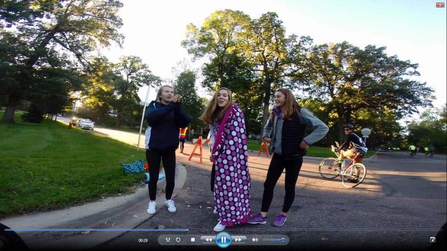 Sophomore volunteers Muriel Lang, Jennie Verhey, and Janie Brunell wave at the GoPro during RubicOnline Editor Mimi Gellers bike ride.