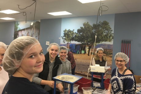 Sophomores Lucie Hoeschen, Annie Kristal, Ethan Dincer and Krista Schlinger pack food at FMSC on Oct. 15. “I was really excited when I heard about the FMSC event because I have been to a FMSC event before and I had fun while also feeling good about the work I was doing” sophomore Muriel Lang said. 