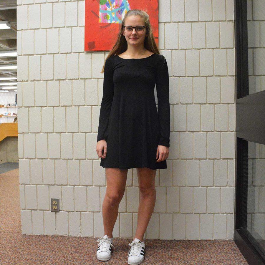 Sophomore Kaia Larsen shows off her monochromatic look of  a black dress and white Adidas sneakers. 