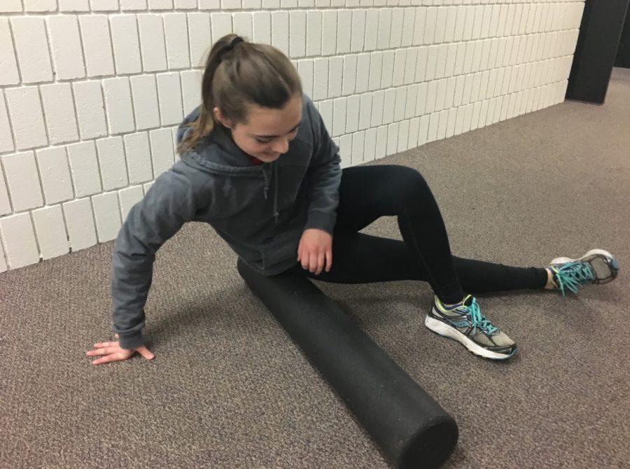 9th grader Kate Thomas rolls out her muscles during a dryland practice. A goal for the team will be to have a really good time and to try to improve ourselves as skiers. I won’t be around next year, but people who will be can try to get better so that next year we can have a really productive season,” senior Katie Brunell said.