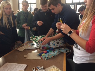 Students wrap gifts at the wrapping party in the lunch  room on Dec. 7. The event was hosted by Community Action and Service as part of the annual Support-a-Family participation.