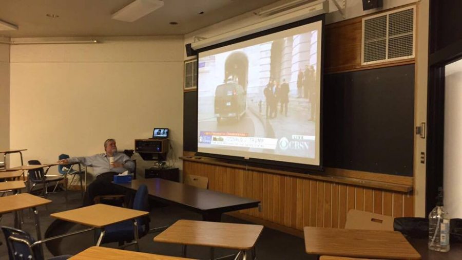 Debate coach Tom Fones watches the lead up to the Inauguration  in the lecture room.