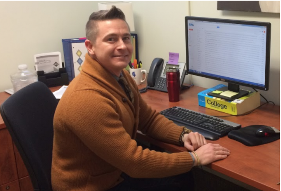 The newest edition to the college counseling department, Carey Otto, poses at his desk in his new office.