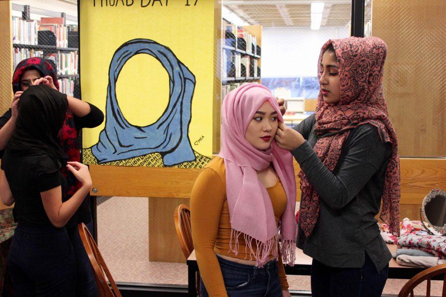 Members of Muslim Student Alliance help female students pin hijab on Feb. 1 for International Hijab Day.