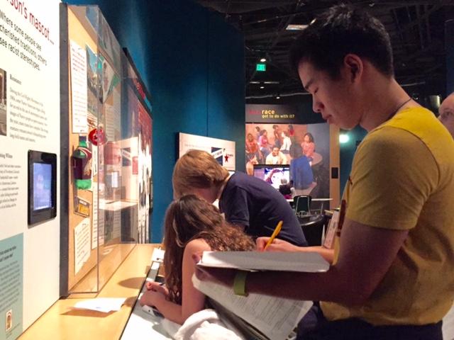 Senior Johnny Addicks O'Toole views the part of the RACE: Are we so different? exhibit at the Science Museum that discusses Native American mascots. "[The exhibit] grabbed my interest more than sitting in a classroom and reading about how science intersects with race," he said. 