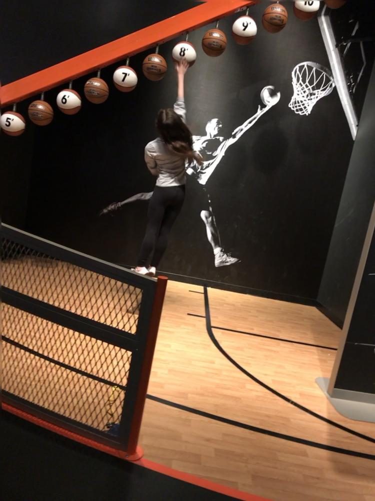 AIMING HIGH. Junior Marlee Baron reaches the eight-foot basketball at the Sportsology exhibit. "I can jump 73 percent as high as a professional basketball player," Baron said.