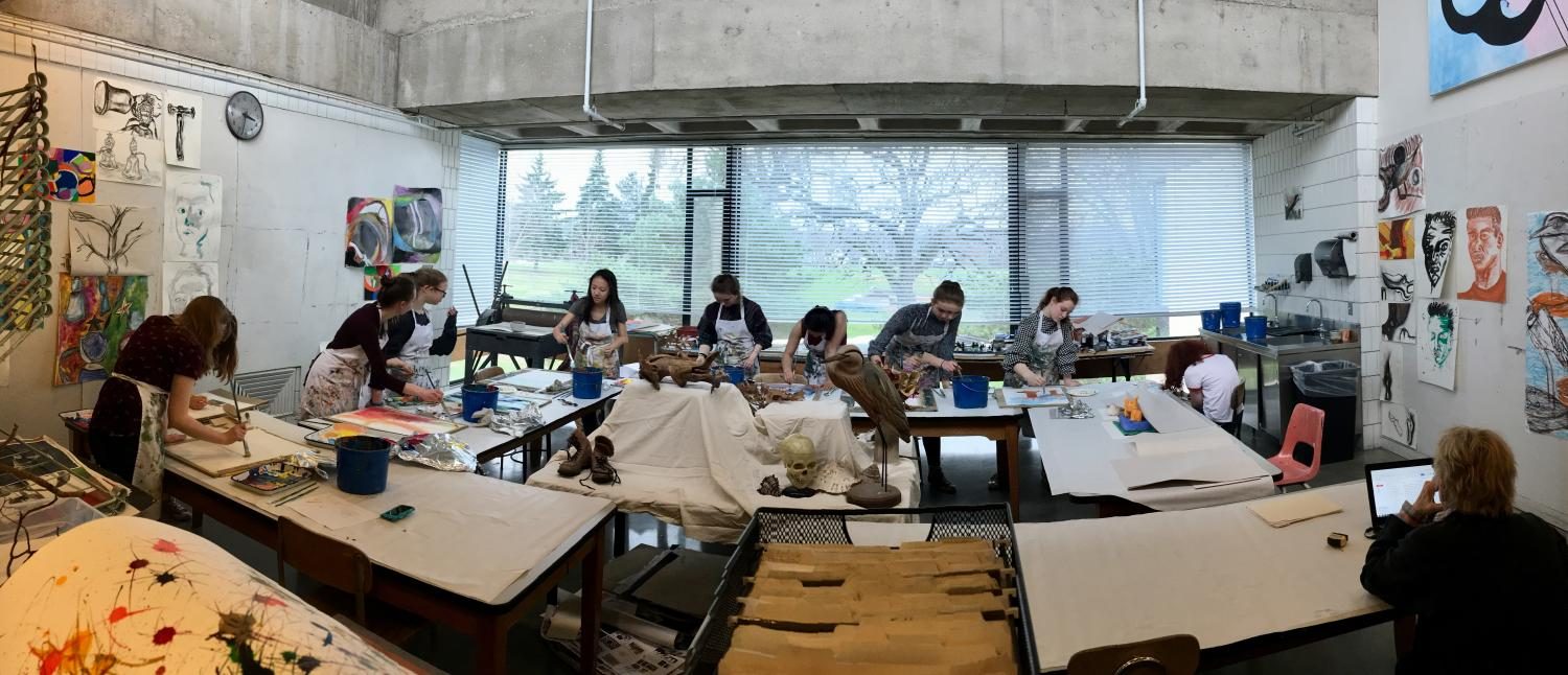 Painters filled every table in the art studio with canvases.