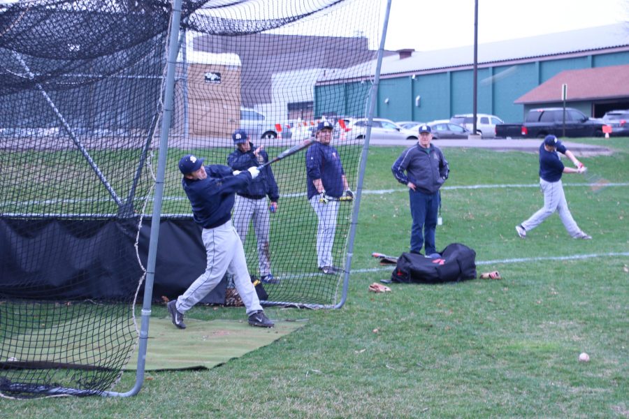 Senior captain Riley Bowman practices hitting baseballs in the batting cage.