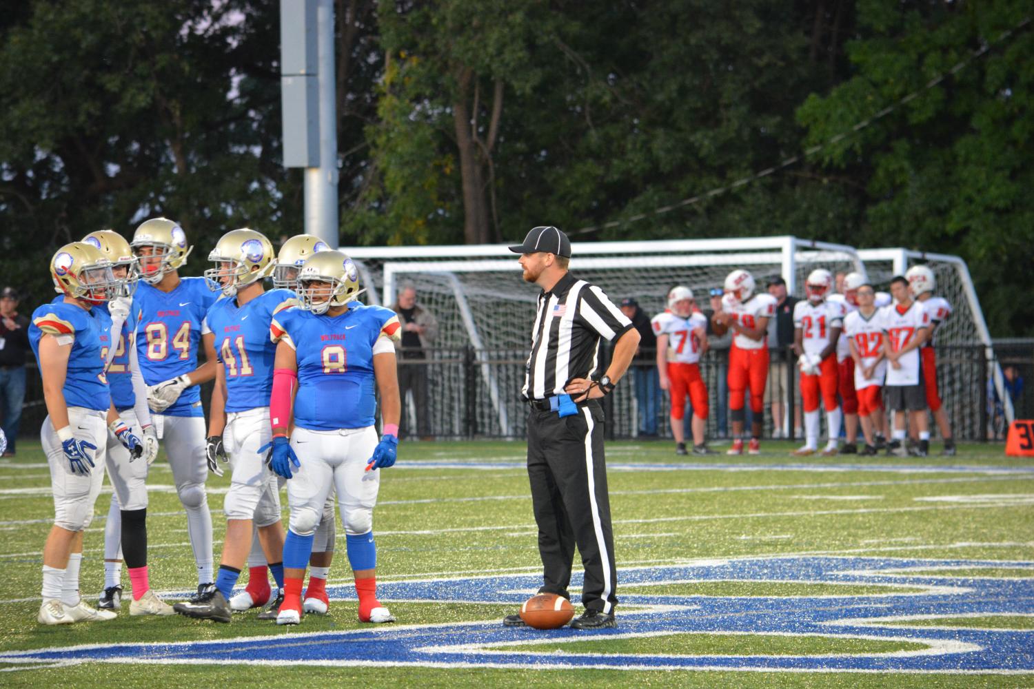 A referee talks to the Wolfpack defense. 