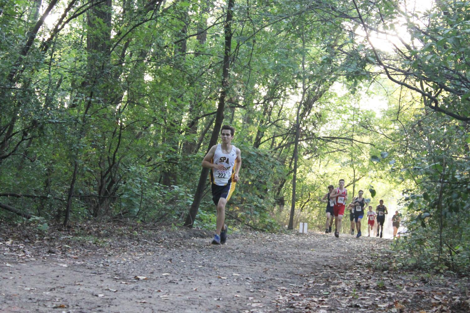 Junior runner Will Rinkoff paces himself through a forest and ahead of the competition during a September meet. “The feeling you get when you perform well in competition makes all the hard work you’ve done seem worth it,” co-captain Jonah Spencer said.