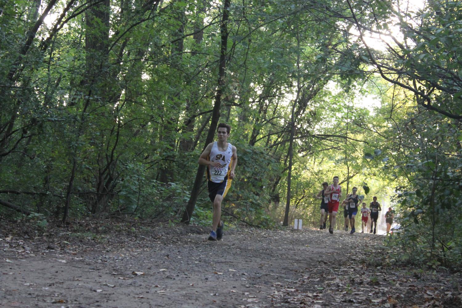 YOUTH MOVEMENT. Junior runner Will Rinkoff paces himself through a forest and ahead of the competition during a September meet. “The feeling you get when you perform well in competition makes all the hard work you’ve done seem worth it,” junior co-captain Jonah Spencer said.