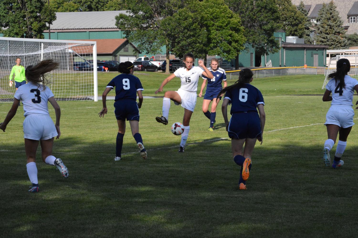 Ninth grader Olivia Lagos controls the ball despite being surrounded by opposing players during a gam against Breck school at Historic Lang Field.