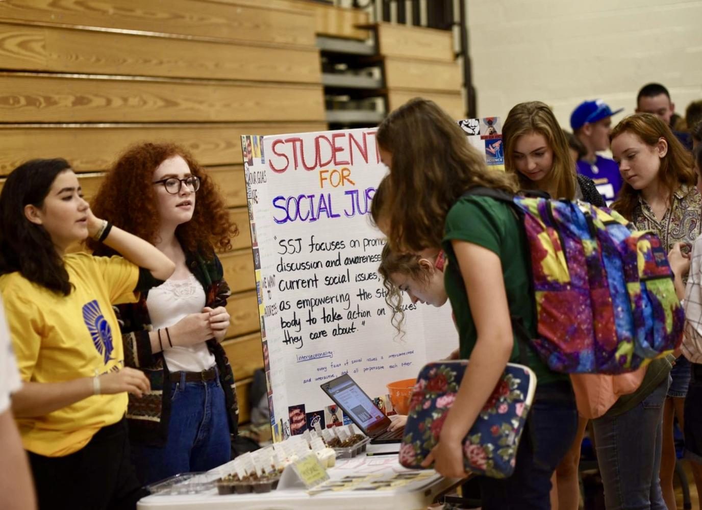 Seniors Numi Katz and Lillian Pettigrew inform 9th graders about their club, HerSpace. 