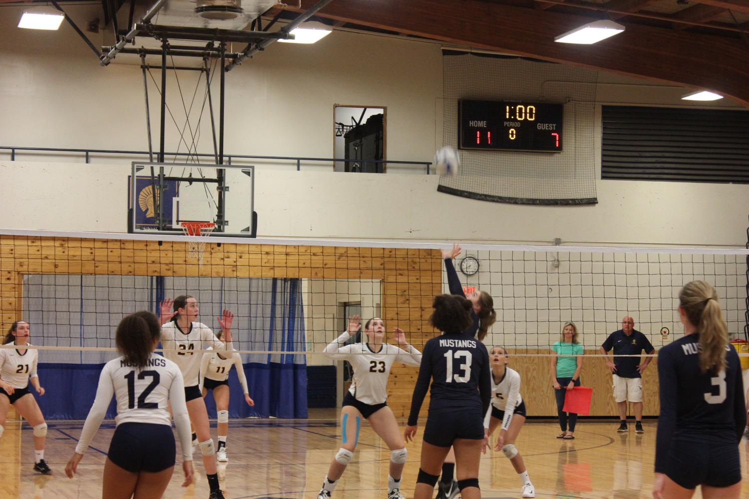 TEAMWORK. Players defend a spike from the Mustangs. 