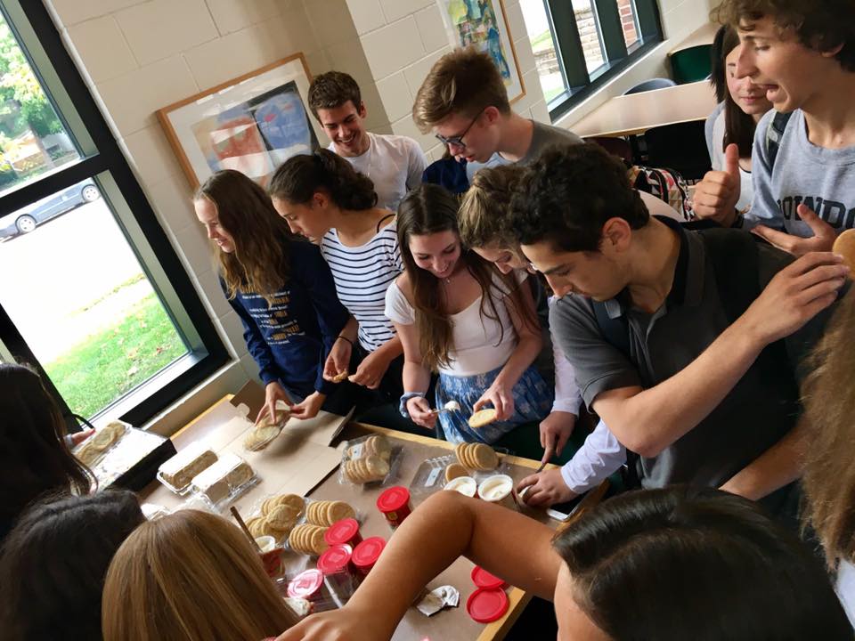 Students crowd around the table to decorate constitution themed cookies at the event.