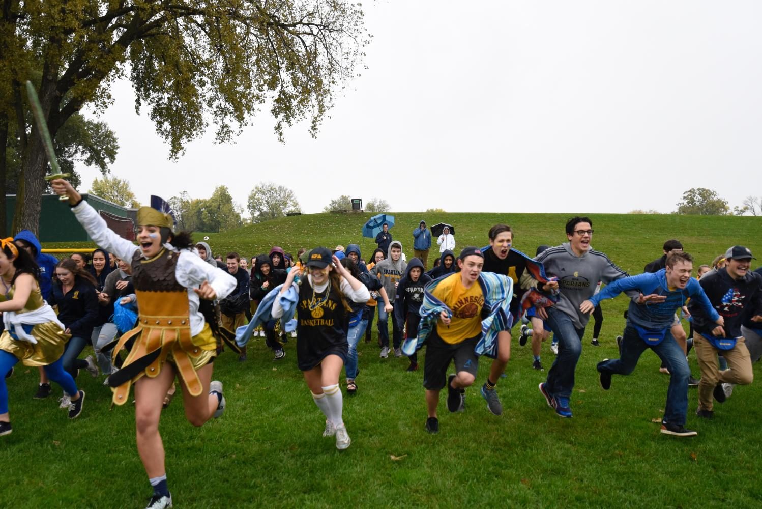 Senior and Spartan Izzy Denny leads students in the annual storming of the field. In spite of the rain, students turned out for the tradition. 