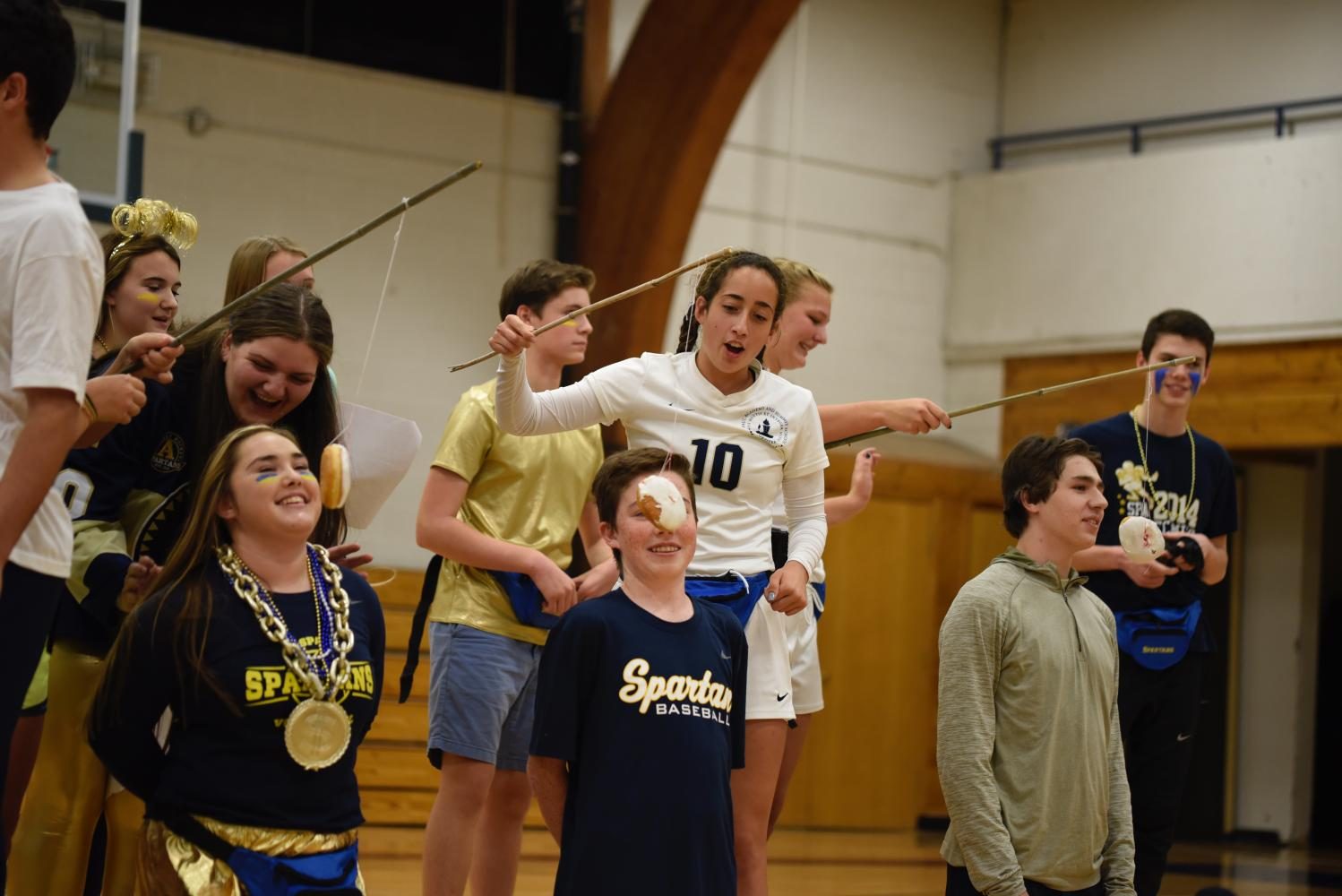 SAC members hold donuts on strings for student volunteers to compete and eat at Pep Fest. 