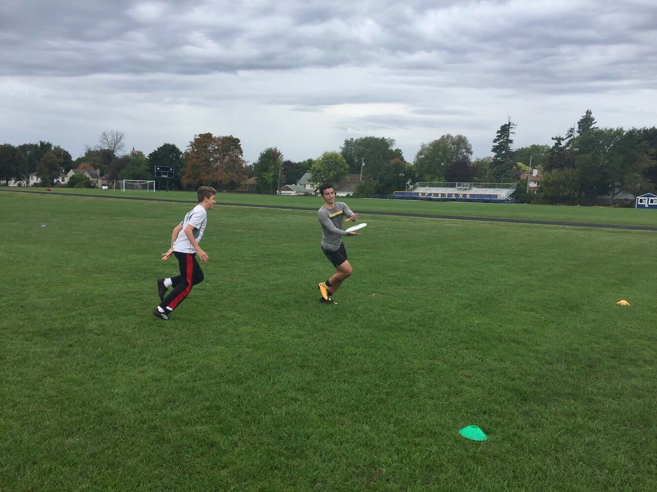 Senior Eli Striker catches the frissbee as ninth grader Henry Cheney runs after him. 