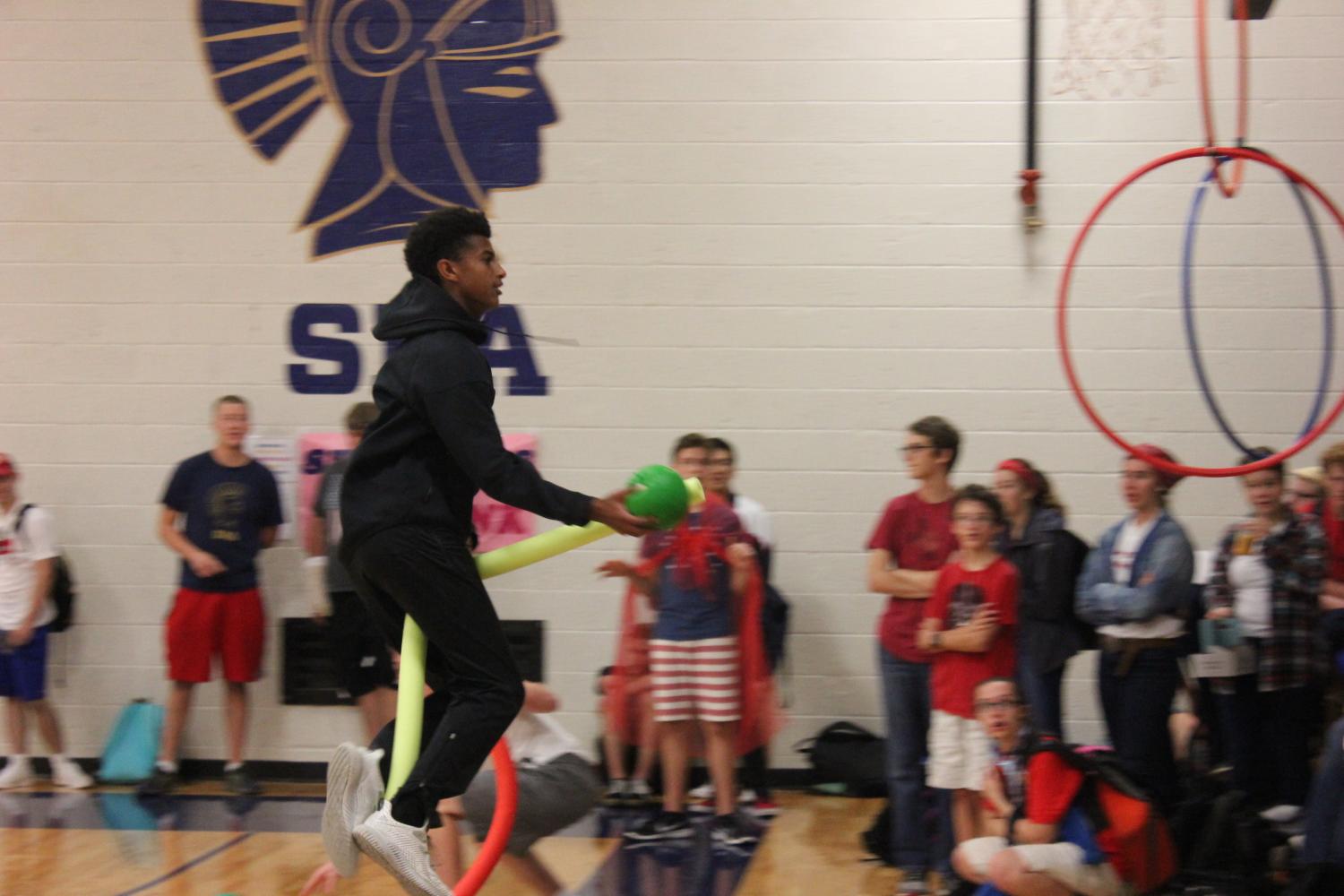 Senior Noah Solomon flies through the air on his broom as he approaches the goal to shoot.