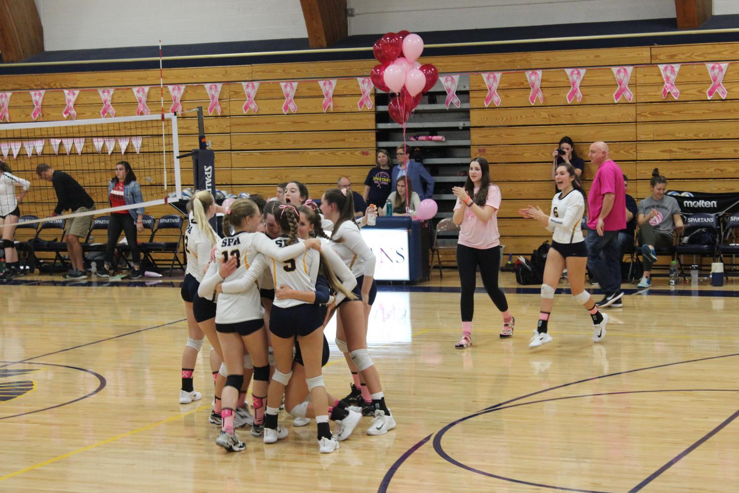 The varsity volleyball team celebrates their win against Minnehaha Academy.