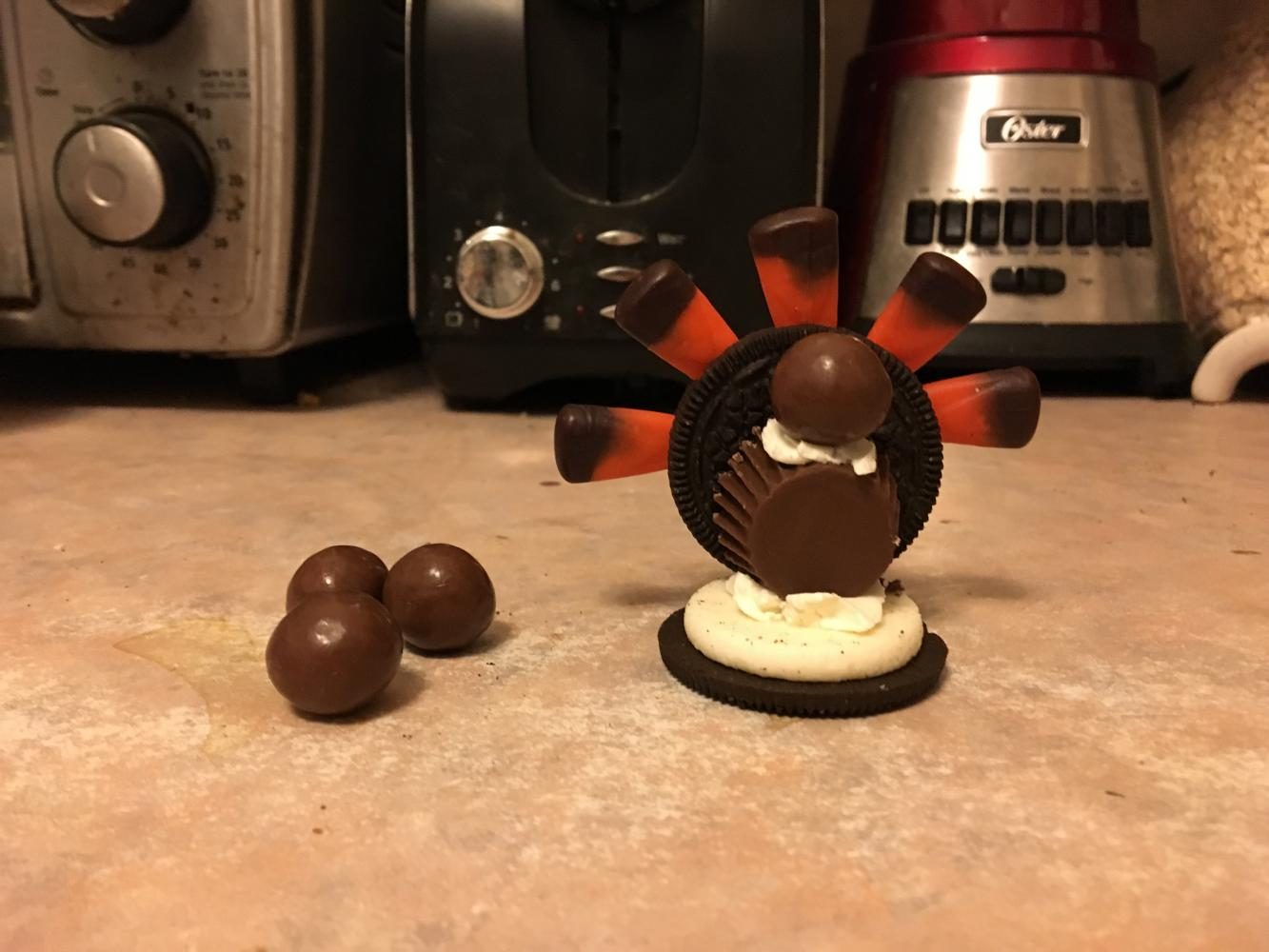 Step 5. Add a drop of frosting to the top of the Reese’s cup and stick a Whopper on top. *Note: or use a Milk Dud or Rolo, as desired.