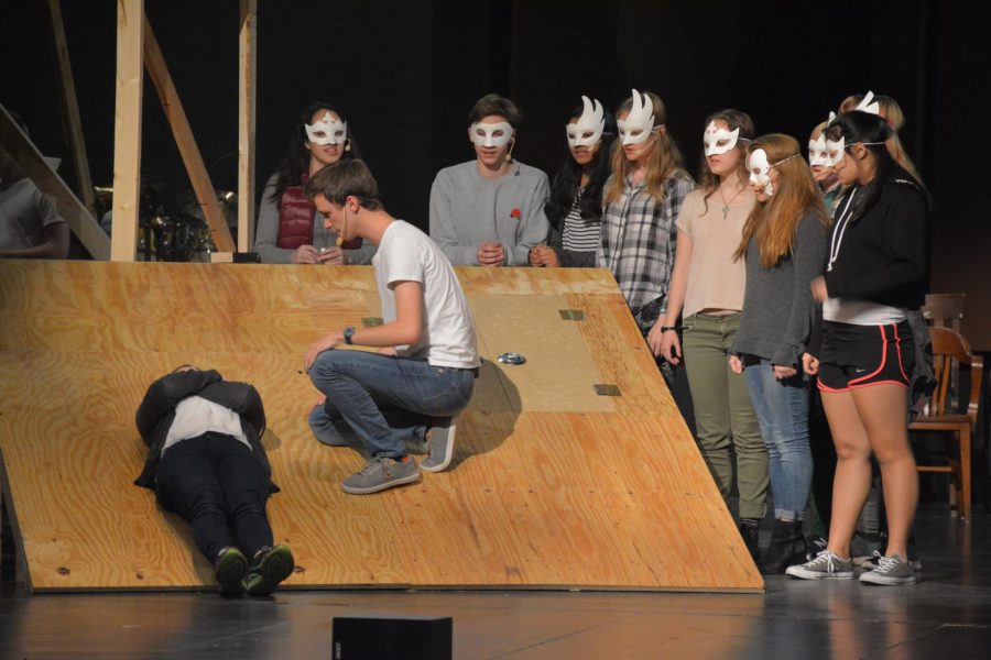 Junior Max Moen grieves in front of a group of faceless singers during rehearsal.