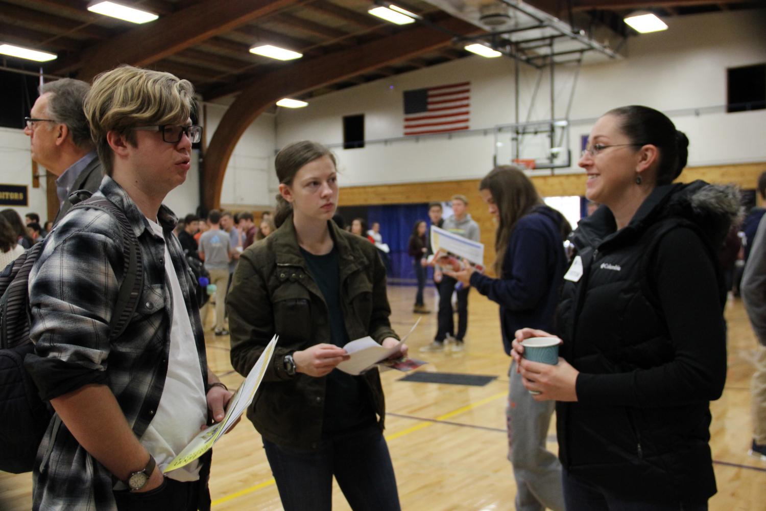 Students learn about the service opportunities available from a representative at the service fair.