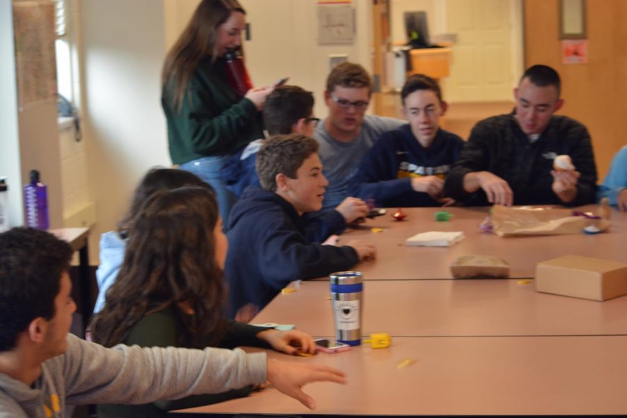 Senior Numi Katz and junior Ethan Less watch as the group shares some food.