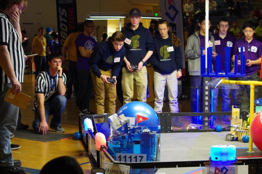 Seniors Grant Gunderson and Michael Hall along with junior Michaela Polley watch their robot in a competition. “For the first part of the competition the robot has to be pre-programmed and that’s very challenging because there are so many things that can go wrong,” Hall said.