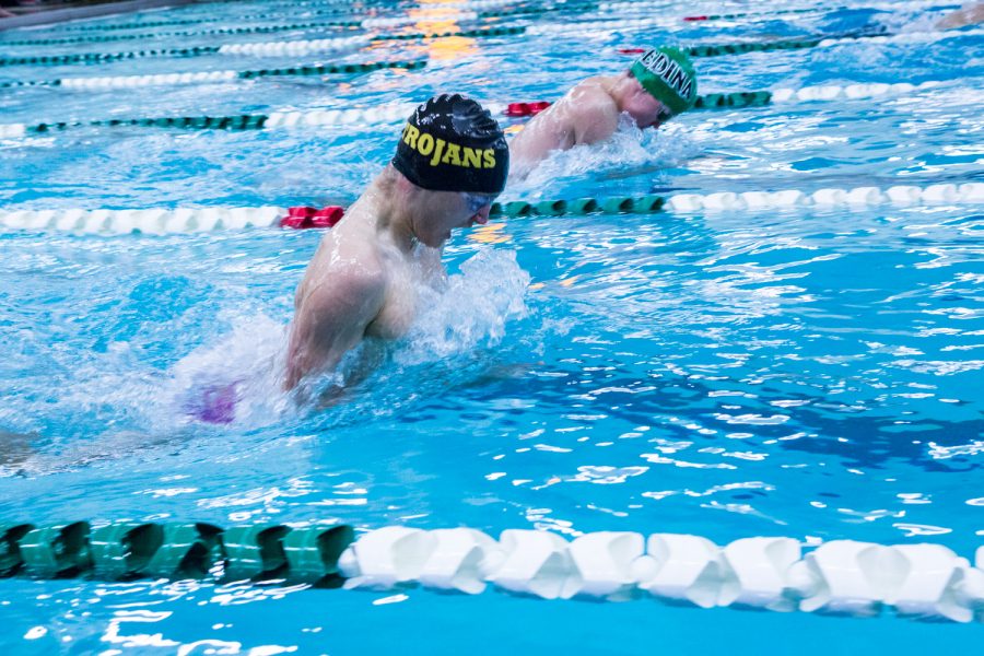 Aidan Alme, a student from Highland Park High School, sweeps the water out of his way to catch his breath. 