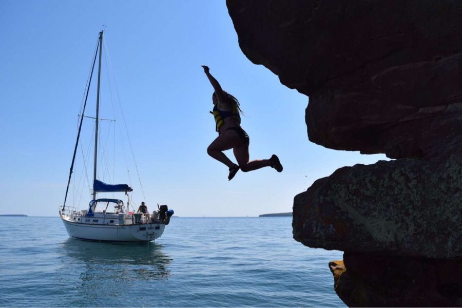 Ninth grader Emma Davies leaps from a cliff on Lake Superior after a day of sailing. It was so cool jumping into the water that I had just been sailing on for hours, Davies said.