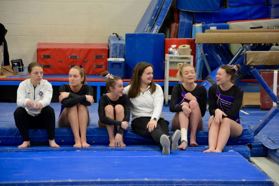 Gymnastics teammates sit together in their small but strong team during a break at the Roseville tournament. In terms of building a team, everyone has been trying really hard to get to know each other, 9th grader Katya Sjaastad said.